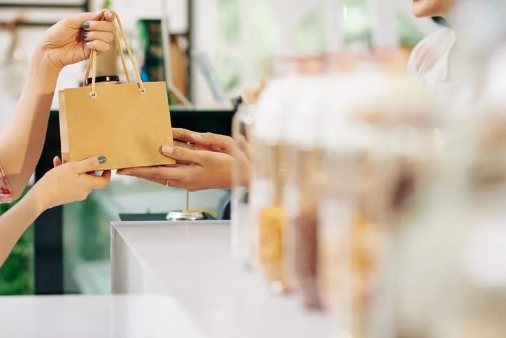 Retail customer receiving a shopping bag